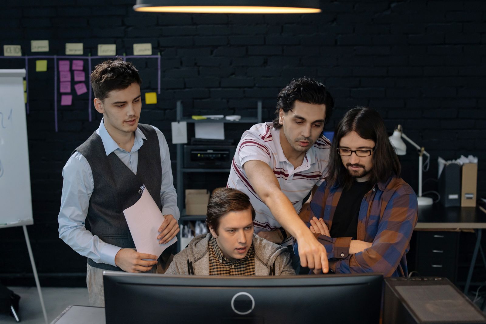 Engineers collaborating around a workstation